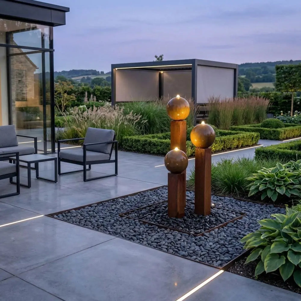 Cortenstahl-Gartenbrunnen Balance Sphera 125 cm mit warmweißer LED-Beleuchtung am Abend