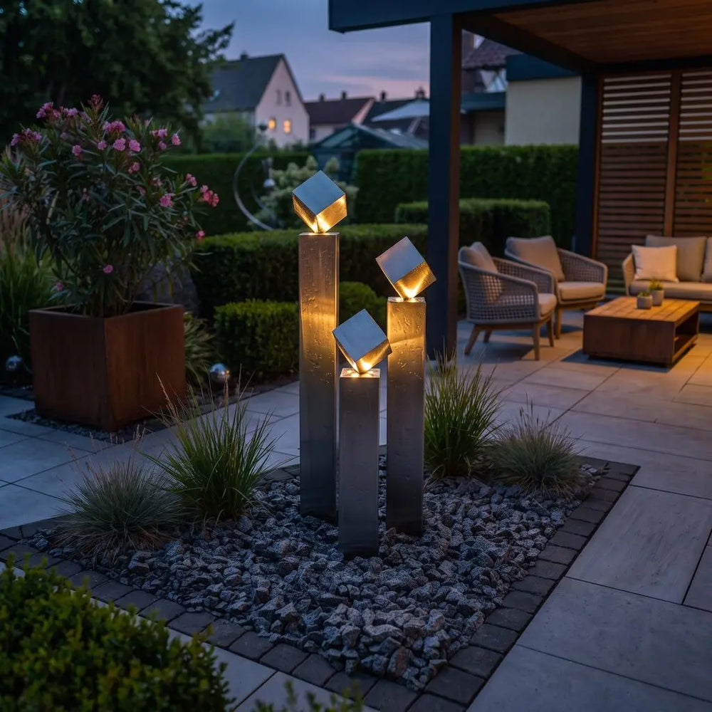 Edelstahl-Gartenbrunnen Balance Cubo 120 cm mit warmweißer LED am Wasseraustritt bei
Dämmerung