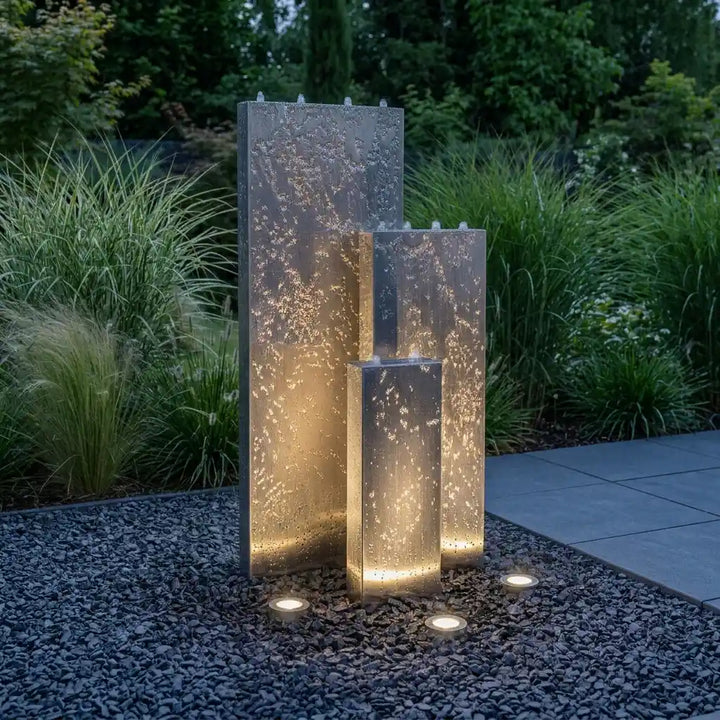 Edelstahl-Gartenbrunnen Linea 120 cm bei Dämmerung mit externer Beleuchtung von unten