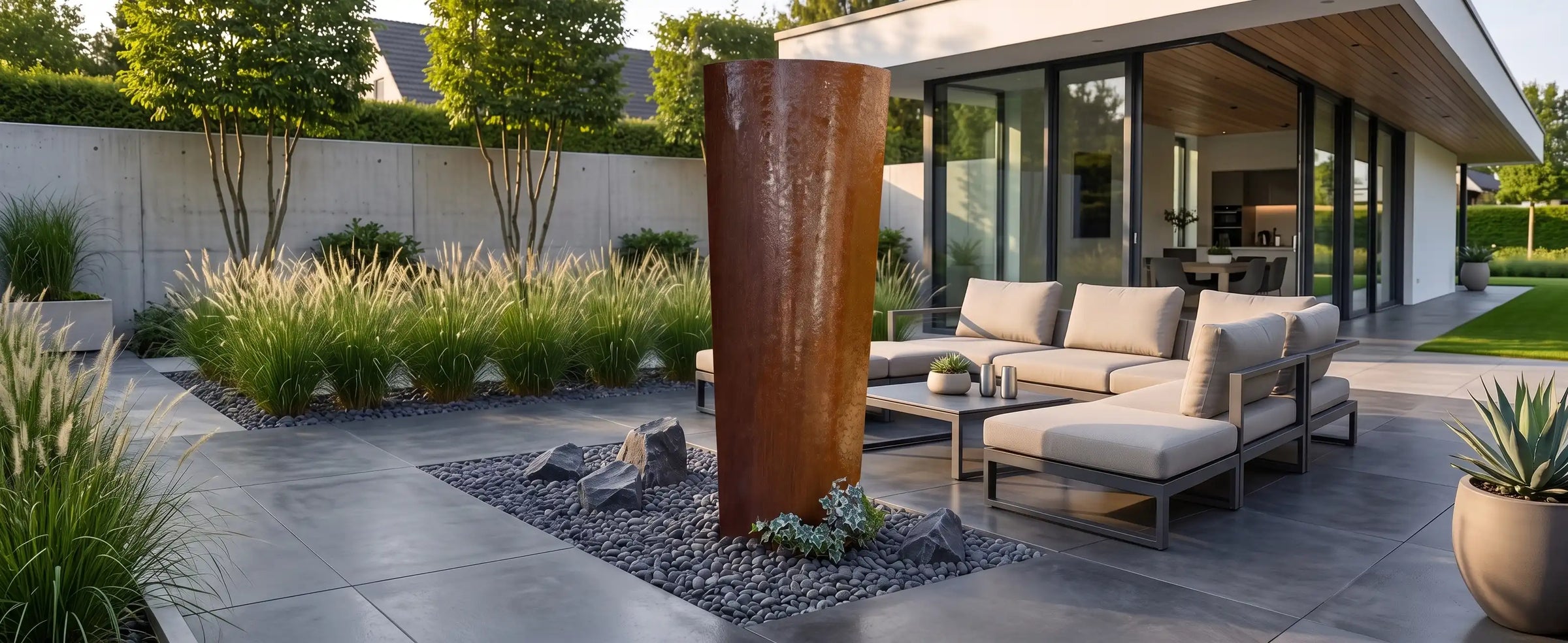 Ellipse Gartenbrunnen aus Cortenstahl in einer modernen Terrasse