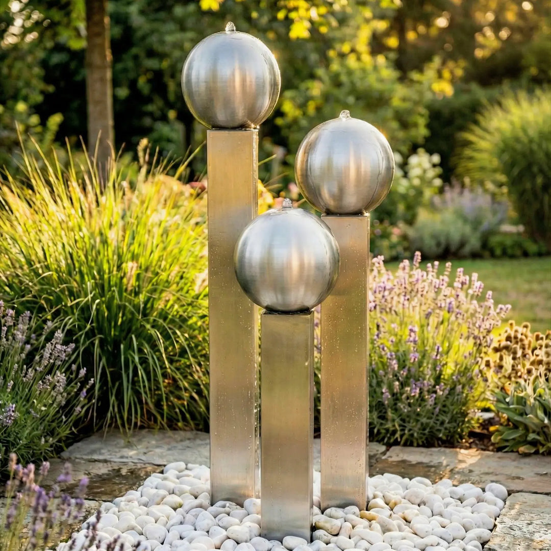 Balance Sphera Edelstahl-Gartenbrunnen 125 cm mit drei Edelstahlkugeln und breitem Becken in einer modernen Gartenanlage