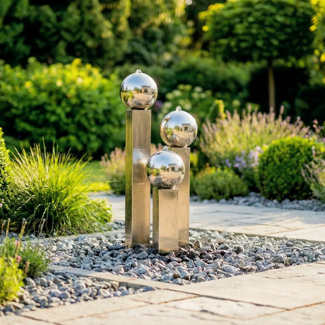 Balance Sphera Edelstahl-Gartenbrunnen 75 cm mit drei kugeln und kompaktem Becken im bepflanzten Garten