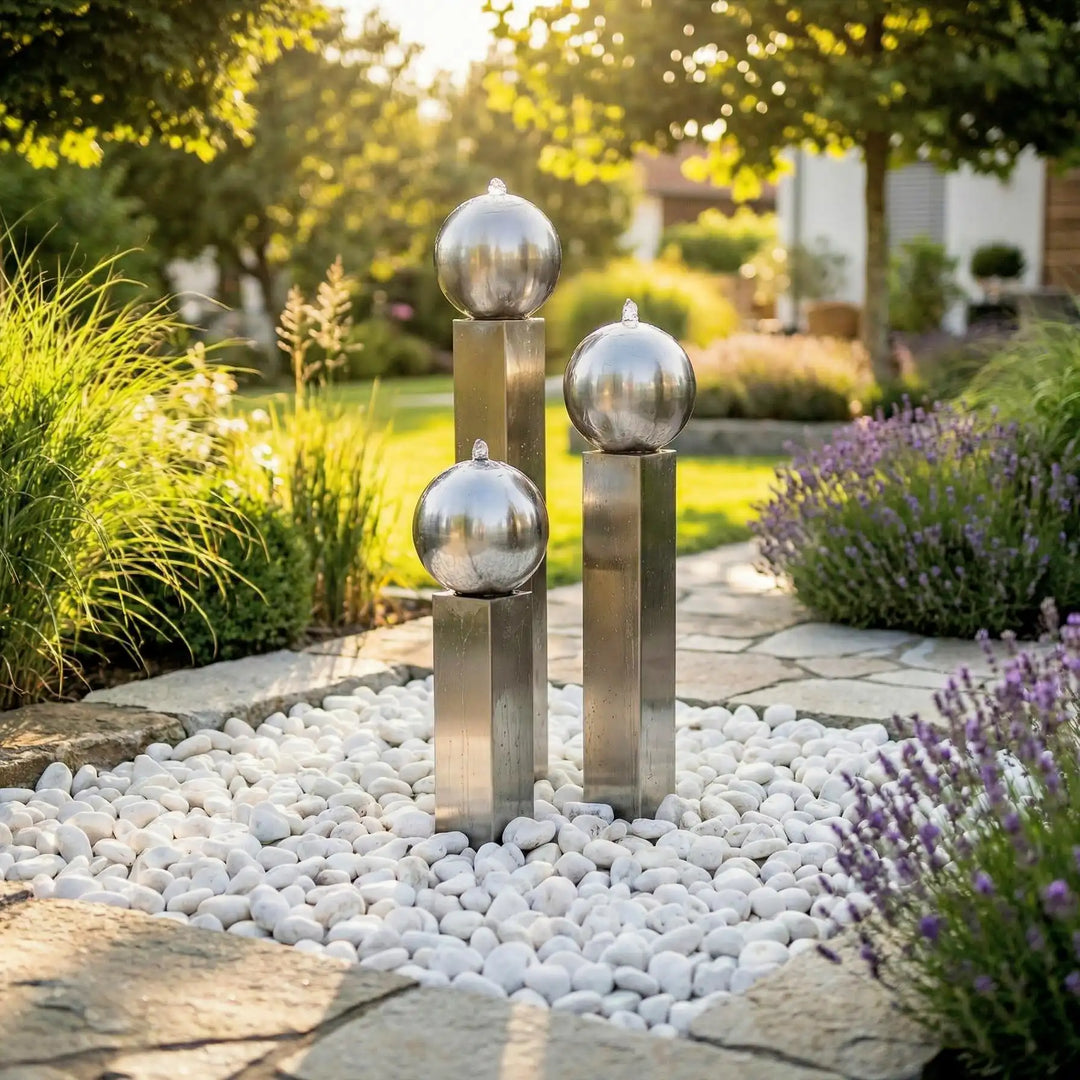 Balance Spera Edelstahl-Gartenbrunnen mit drei unterschiedlich hohen Säulen und kugeln im modernen Garten