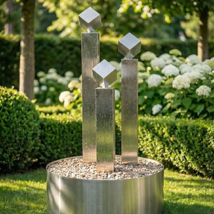 Moderner Edelstahl-Gartenbrunnen Balance Cubo 120 cm im 3er-Set mit drei Würfeln freistehend im Garten
